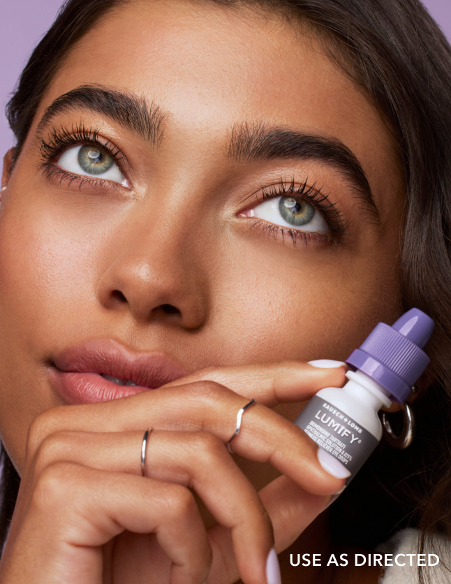 Close up of a woman holding a Lumify eye drops bottle